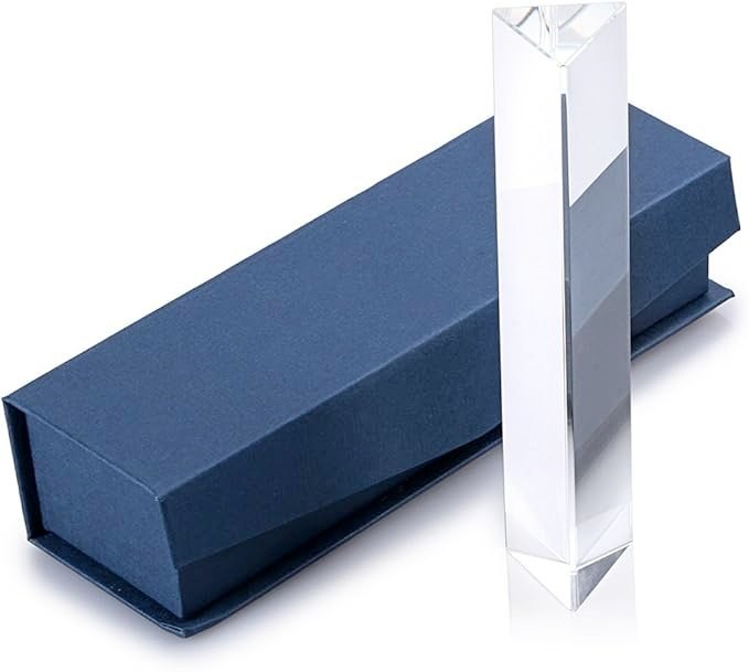 A handheld triangular crystal prism in a navy magnetic gift box